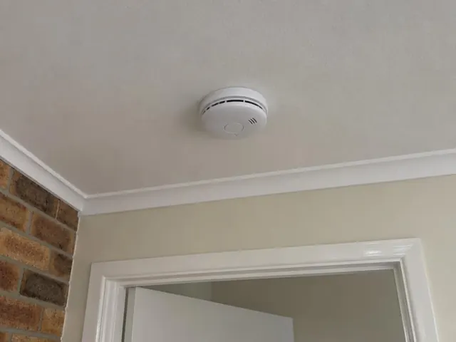Ceiling-mounted smoke alarm above a doorway in a home interior in Coolangatta